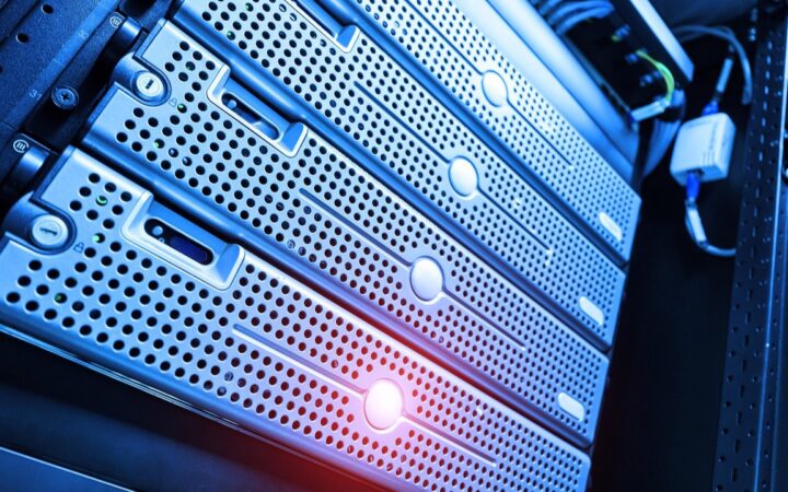 Servidores metálicos montados en un rack, iluminados con luz azul y un destello rojizo