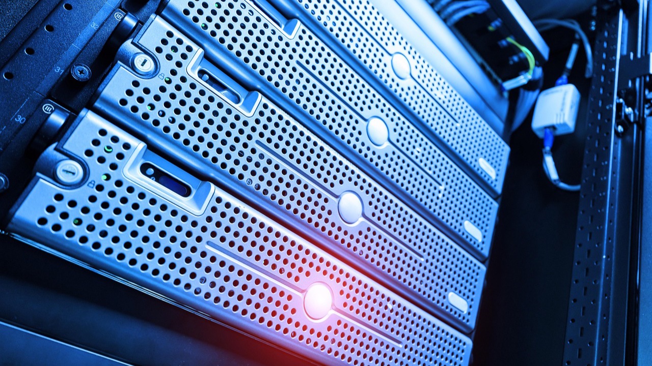 Servidores metálicos montados en un rack, iluminados con luz azul y un destello rojizo