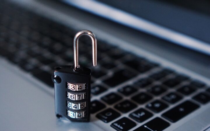 Candado de combinación negro sobre el teclado de una laptop plateada
