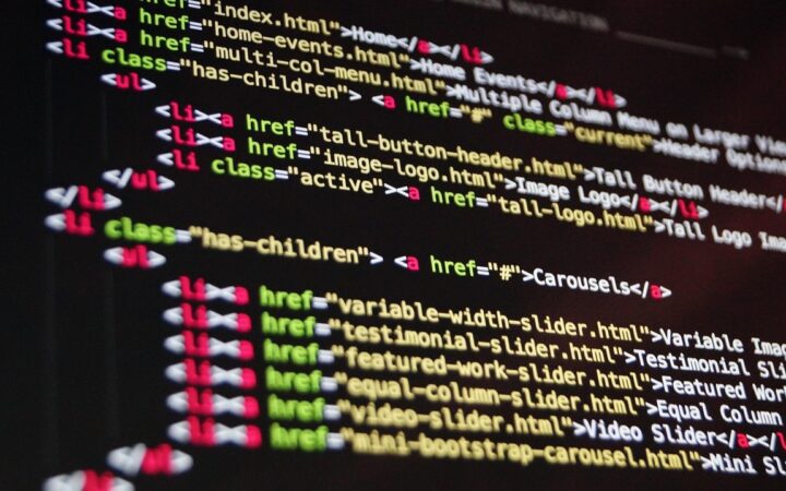 Pantalla de computadora con código HTML de un menú de navegación en colores sobre fondo oscuro