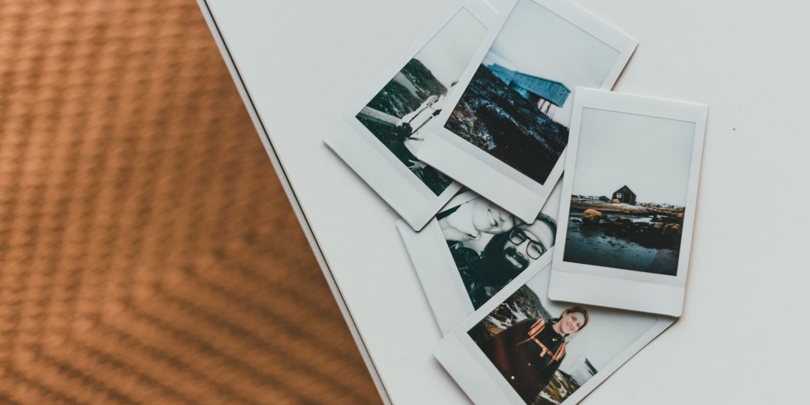 Fotos instantáneas de paisajes y personas esparcidas sobre una mesa blanca