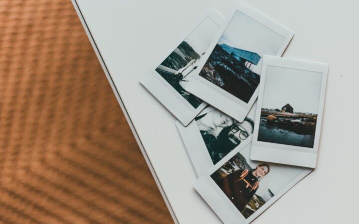 Fotos instantáneas de paisajes y personas esparcidas sobre una mesa blanca