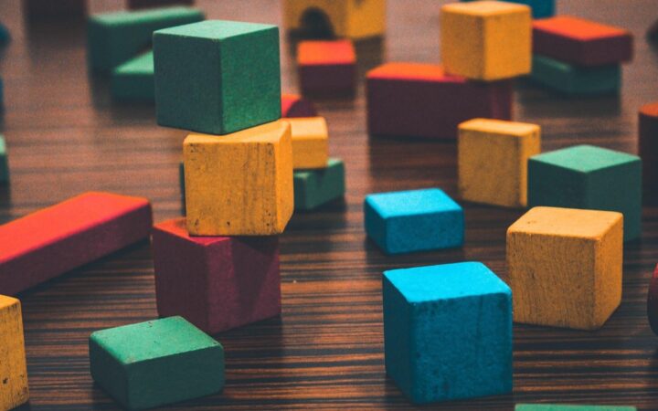 Cubos de madera de colores apilados sobre una mesa oscura