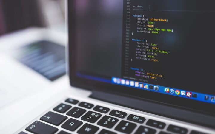 Pantalla de una laptop con líneas de código de una hoja de estilos sobre un escritorio