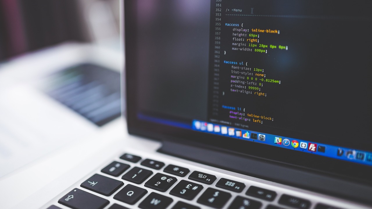 Pantalla de una laptop con líneas de código de una hoja de estilos sobre un escritorio