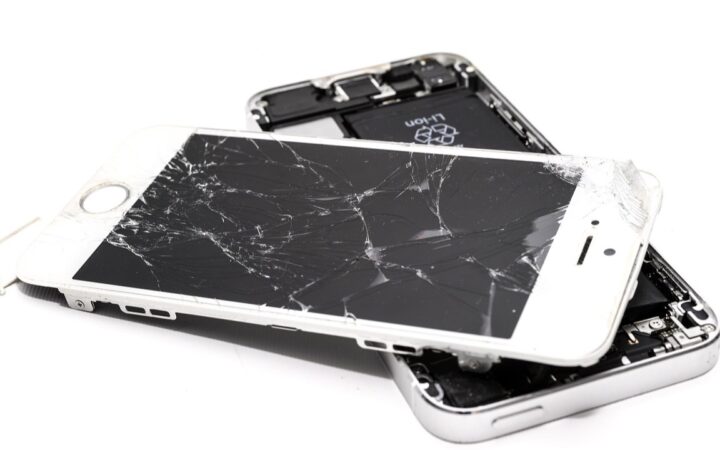 Celular desarmado con la pantalla estrellada separada del cuerpo, listo para reparación