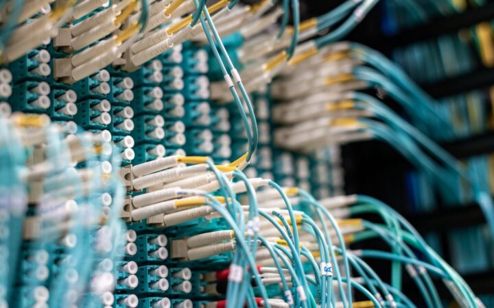 Cables de fibra óptica azules conectados a un panel de red en un centro de datos