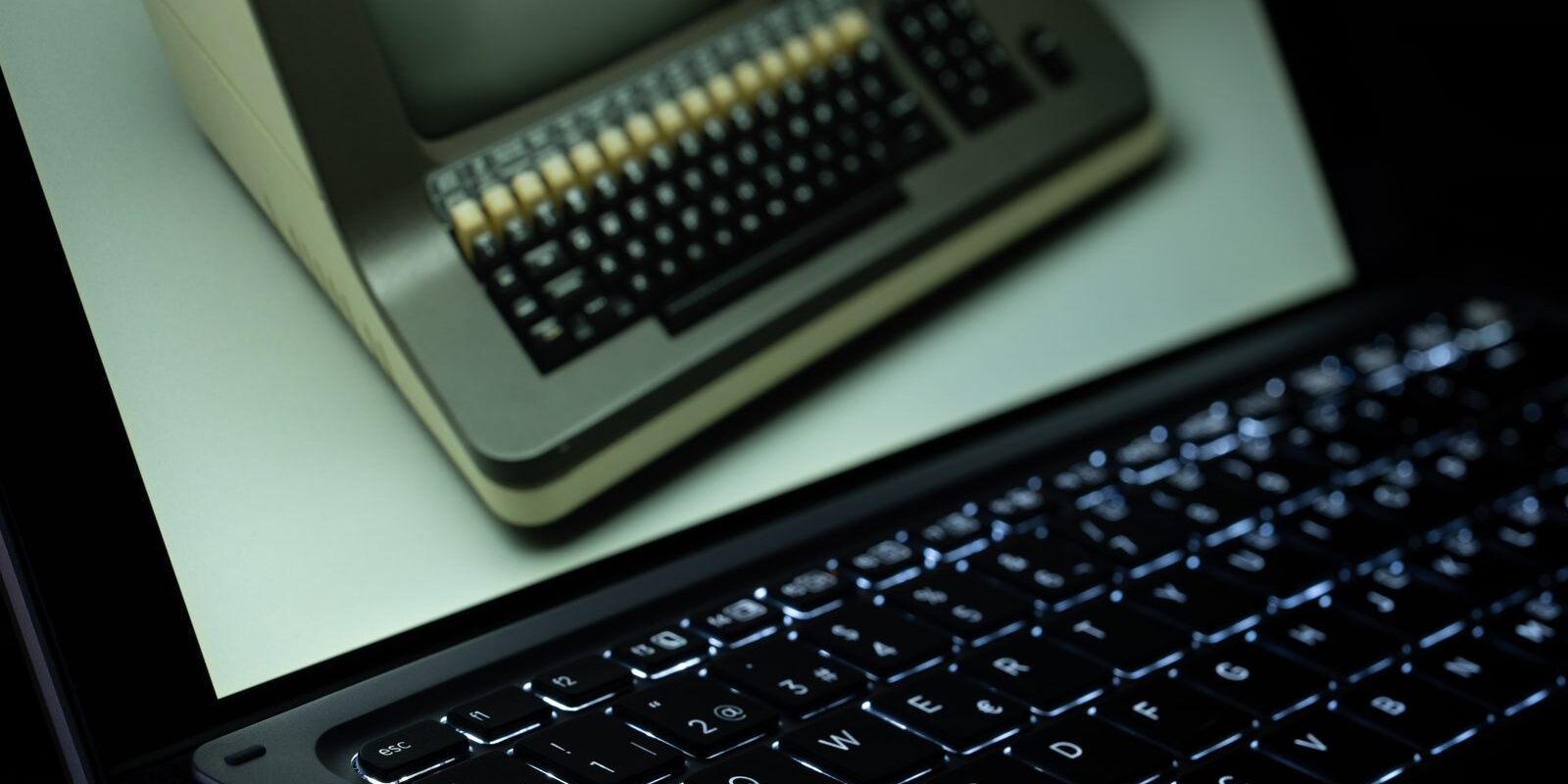 Pantalla de una laptop moderna que muestra una computadora antigua con teclado de teclas beige