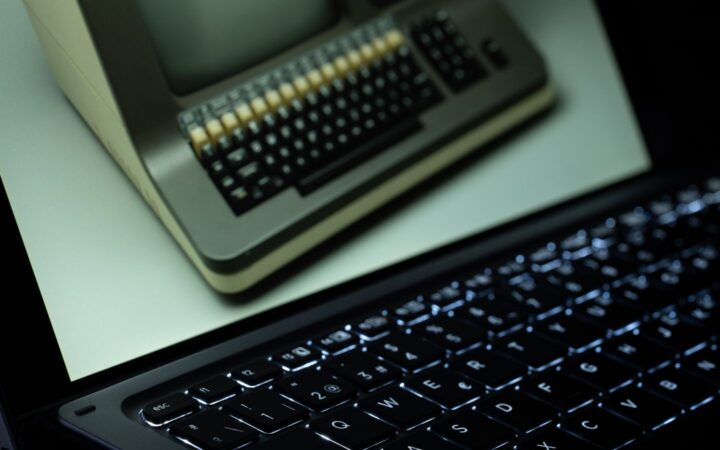 Pantalla de una laptop moderna que muestra una computadora antigua con teclado de teclas beige