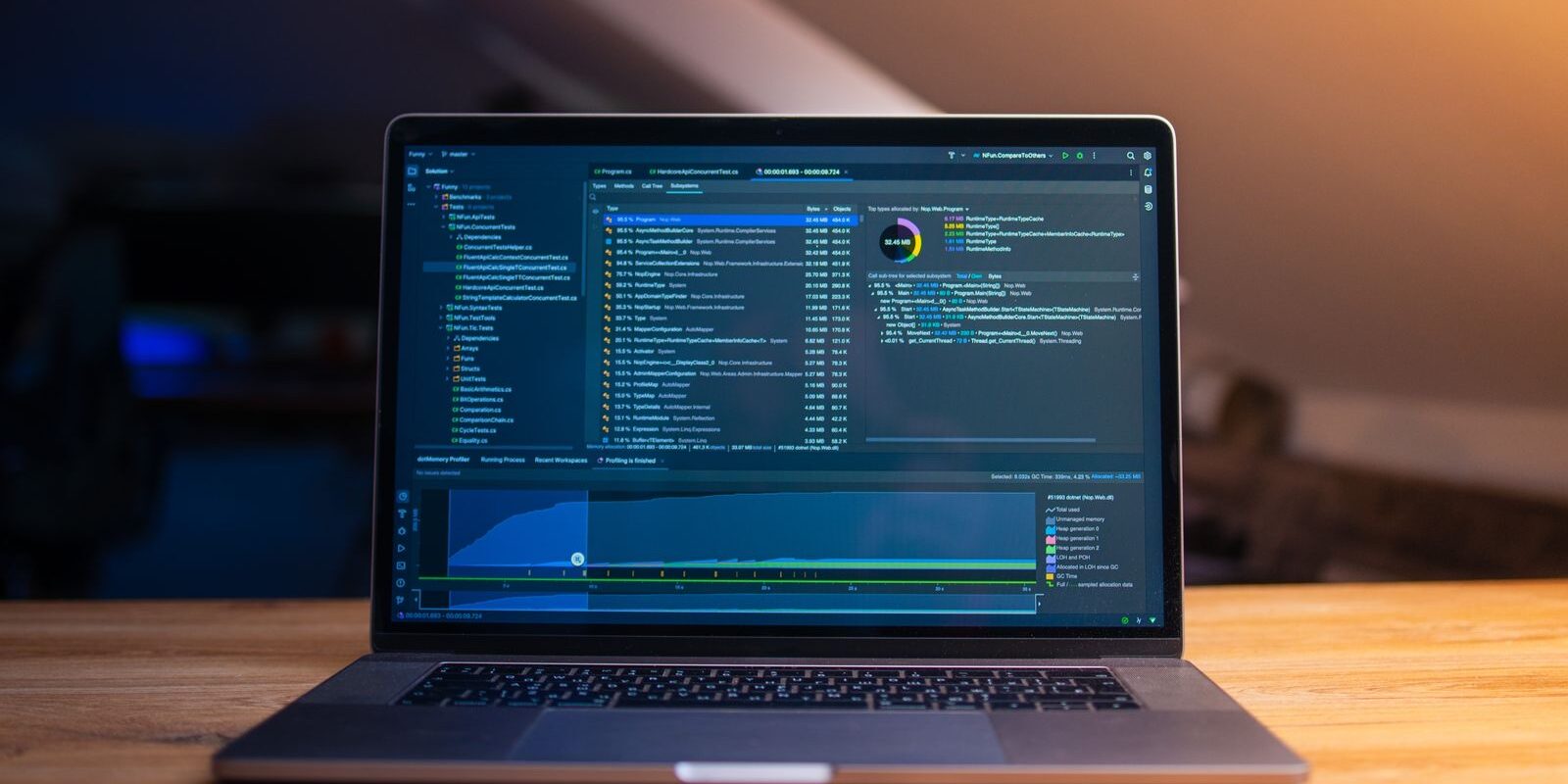 Laptop abierta sobre un escritorio de madera mostrando un entorno de desarrollo