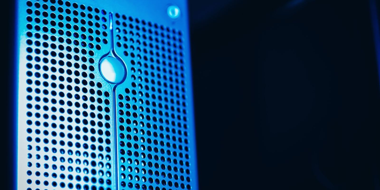 Frente de un servidor con rejilla metálica iluminado con luz azul en un centro de datos