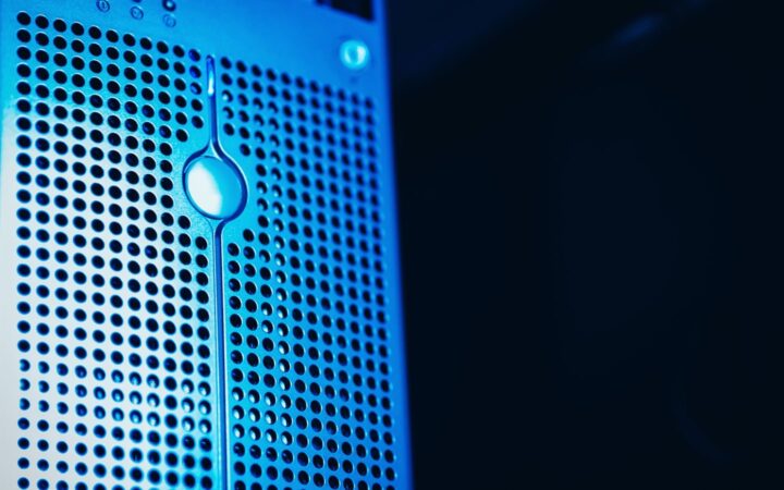 Frente de un servidor con rejilla metálica iluminado con luz azul en un centro de datos